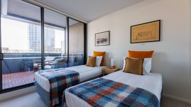 A hotel room with two beds, a balcony, and a city view. - Marvel & Waterfront Escape - Docklands (Docklands)