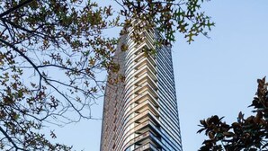 A modern high-rise building with a curved facade, surrounded by urban streets and parked cars. - Marvel & Waterfront Escape - Docklands (Docklands)