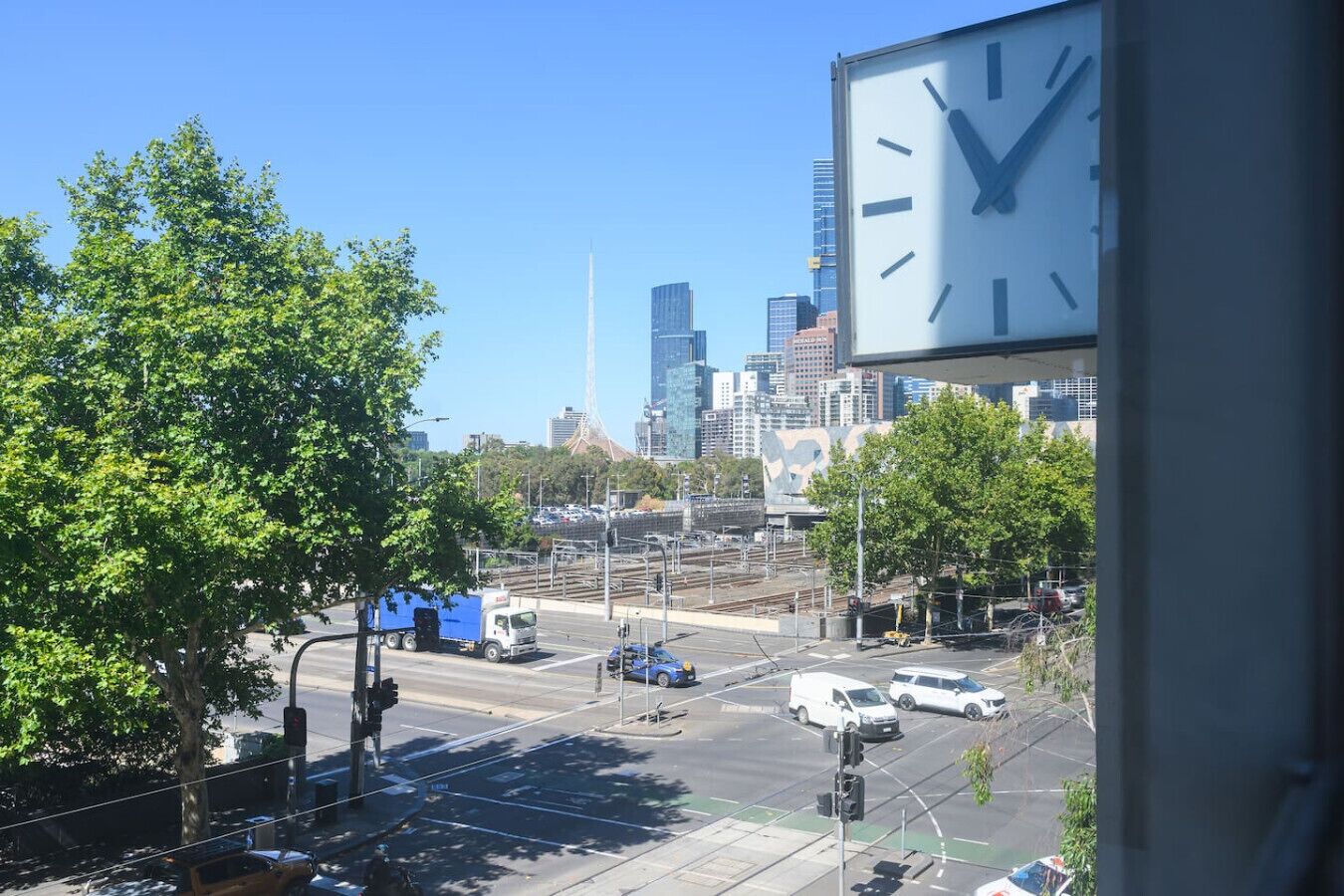 A cityscape with a large clock, buildings, and a tree.