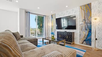 Una sala moderna con un sofá, un televisor de pantalla plana y una chimenea.