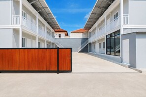Un bâtiment moderne doté d’une cour intérieure, d’une clôture en bois et surplombant un ciel dégagé.