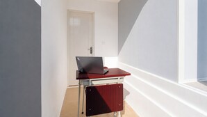 A small room with a desk and a laptop, a door, and a window. - Hotel O near Living Word Mall formerly T (Denpasar)