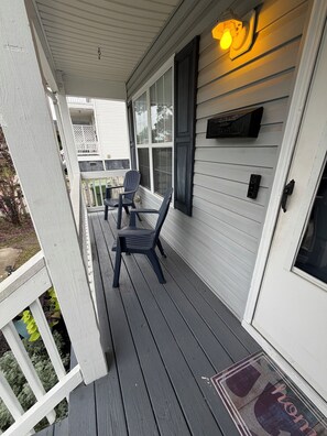 A porch with two chairs and a table, a door with a mailbox, and a light fixture above. - Awesome 3-bedroom house in charming downtown Wilmington. Minutes from River Walk (Wilmington)