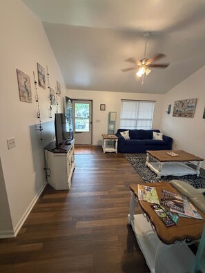 A spacious living area with a ceiling fan, a blue sofa, a coffee table, and a television. - Awesome 3-bedroom house in charming downtown Wilmington. Minutes from River Walk (Wilmington)