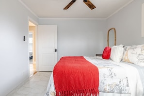 A bedroom with a bed, a red throw blanket, a white door, and a ceiling fan. - The Phoenix Haven Resort Village | Pool & Gym | (Phoenix)