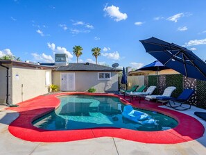 A swimming pool with a red edge, surrounded by lounge chairs and a covered area with umbrellas. - The Phoenix Haven Resort Village | Pool & Gym | (Phoenix)