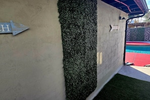 A concrete wall with a vertical garden and a metal sign with an arrow. - The Phoenix Haven Resort Village | Pool & Gym | (Phoenix)