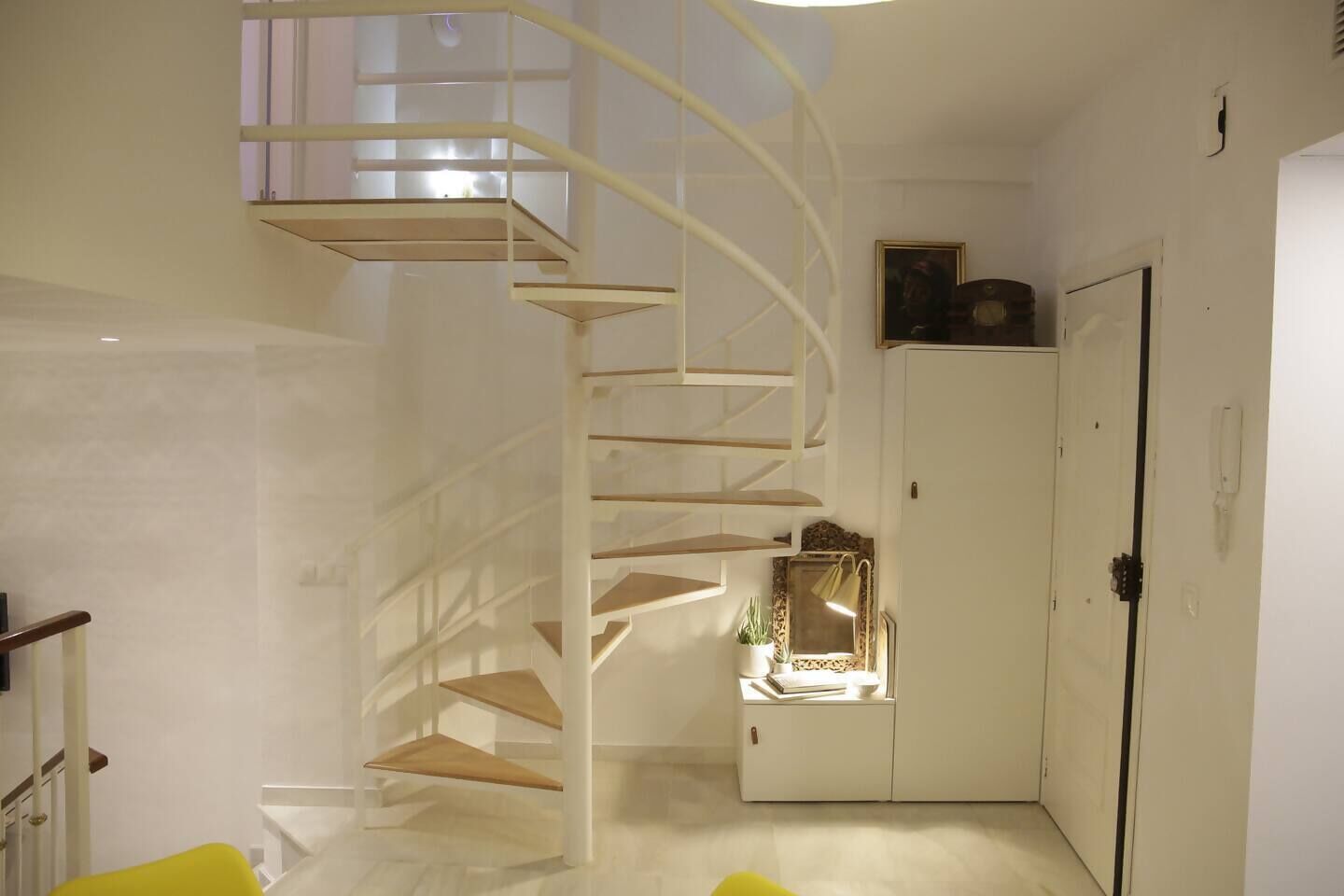 Una escalera de caracol en un pasillo que lleva a una puerta.