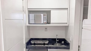 Eine kleine Küche mit Mikrowelle, Herd und Kühlschrank.