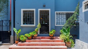 A blue building with a set of steps leading to a door, flanked by two windows with metal bars. - Spacious Colonial House - 6 Bedrooms Near the Zócalo in Puebla (Heroica Puebla de Zaragoza)