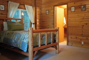 A wooden cabin bedroom with a bed, curtains, and a window. - Charming Log Cabin Tucked Away Near Cle Elum (Cle Elum)