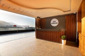 A reception area with a sign reading 'Sky Garden,' a potted plant, and a view of mountains in the background. - Alivaa Hotel, Mcleodganj With Best Dhauladhar View (Dharamshala)