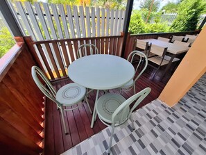 An outdoor patio with a round table and four chairs. - Sai Pan House Phrae (Sung Men)
