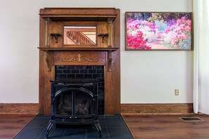 A fireplace with a black screen door, a wooden mantel, and a framed painting of flowers on the wall. - Newly Renovated Lakefront • Private Dock • Game Room • Flat Backyard ... (Eddyville)