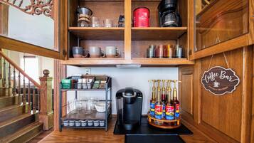 Ein Bereich mit einer Kaffeebar, einer Keurig-Kaffeemaschine, Folgers-Kaffee und verschiedenen Kaffeetassen.