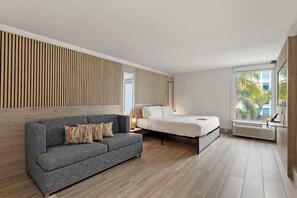 Ein modernes Schlafzimmer mit einem grauen Sofa, einem Bett, einer Wand aus Holzlamellen, einem Fenster mit Blick und einer eingebauten Klimaanlage.