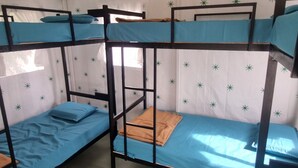 A bunk bed room with a patterned ceiling and a window.