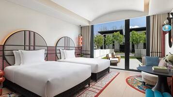 A modern hotel room with a large bed, a desk, and a view of the outdoors.