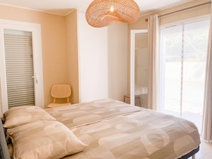 A bedroom with a bed, a chair, a door, and a window. - Nice holiday home with pool and wide views (Saint-Julien-le-Montagnier)