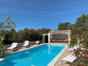 A swimming pool with lounge chairs and a covered seating area. - Nice holiday home with pool and wide views (Saint-Julien-le-Montagnier)