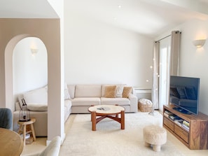 A modern living room with a sofa, coffee table, and TV stand. - Nice holiday home with pool and wide views (Saint-Julien-le-Montagnier)