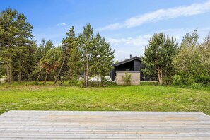A cabin with a deck in a forested area.