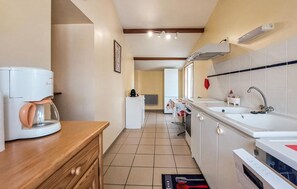 A kitchen with a coffee maker, a refrigerator, a sink, and a tiled backsplash. - Lovely apartment in épargnes with WiFi (Épargnes)