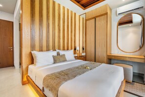 Ein modernes Hotelzimmer mit einem großen Bett, Holzwandverkleidung, einem integrierten Schreibtisch und einer Klimaanlage.
