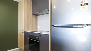 Eine Küche mit einem Edelstahl-Kühlschrank, Holzschränken und einem eingebauten Backofen.