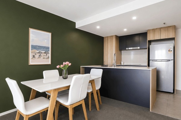 Dining space set for four beside the fully equipped kitchen.