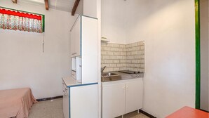 A compact kitchen with a sink, cabinets, and a tiled backsplash. - 1 bedroom nice home in CALCATOGGIO (CALCATOGGIO)