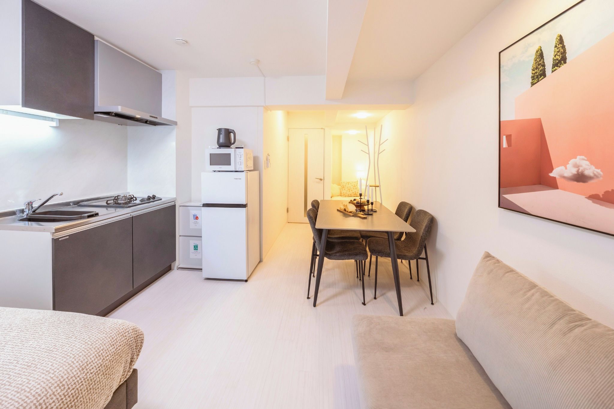 Een knus woongedeelte met kitchenette, eethoek en een bank.