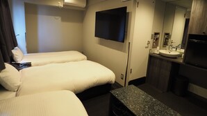 Camera d'albergo con due letti, una TV a schermo piatto, bagno con lavandino e specchio, e condizionatore d'aria.