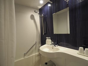 Ein Badezimmer mit Waschbecken, Spiegel und Dusche.