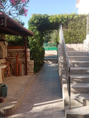 Ein gepflasterter Weg, der zu einer Treppe mit Metallgeländer führt.