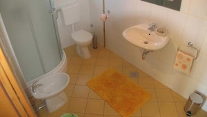 Un baño con inodoro, lavamanos y ducha.