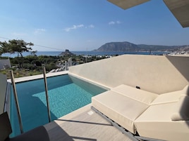 Zona de piscina con vistas al mar y a la montaña.