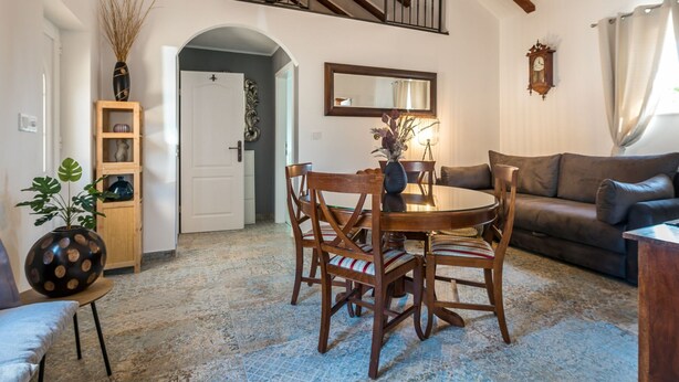 A dining area with a round table, chairs, and a staircase leading to an upper level. - Holiday Home Rider - Two Bedroom Holiday Home With Outdoor Pool (Sibenik)