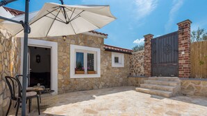 A stone building with a patio, a covered seating area, and a gated entrance. - Holiday Home Rider - Two Bedroom Holiday Home With Outdoor Pool (Sibenik)