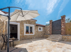 A stone building with a patio, a covered seating area, and a gated entrance. - Holiday Home Rider - Two Bedroom Holiday Home With Outdoor Pool (Sibenik)