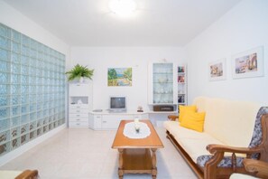 A living room with a sofa, a coffee table, a TV, a cabinet, and a bookshelf. - Apartments Paco - Superior Two-bedroom Apartment With Terrace and Sea View A1 (Postira)