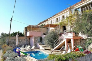 A two-story building with a swimming pool, outdoor seating, and a staircase leading to an upper level. - Villa Tony - Five Bedroom Villa With Terrace, Swimming Pool and Sea View (Dubrovnik)