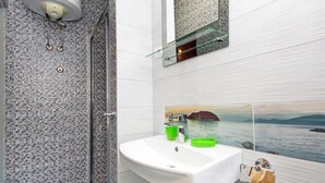 A modern bathroom with a glass shower enclosure, a white sink with a green soap dish, and a large mirror above the sink. - Apartments Ribarevic - Studio With Balcony (Makarska)