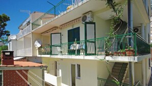 A multi-story residential building with balconies, satellite dishes, and a staircase. - Apartments Ribarevic - Studio With Balcony (Makarska)