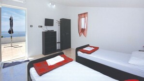 A hotel room with two beds, a TV, a wardrobe, and a balcony with a view. - Villa Blanka - Six Bedroom Villa With Swimming Pool and Sea View (Podgora)