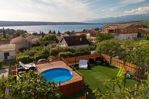 Ein Wohngebiet mit Schwimmbad, umzäunter Garten und Häusern mit roten Ziegeldächern.