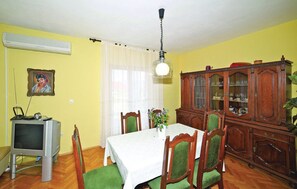 A dining area with a table, chairs, a television, and a cabinet. - Apartments Halilovic - Two Bedroom Apartment 1 (Trogir)