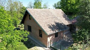 A single-story brick house with a sloped roof, surrounded by greenery and trees. - Holiday Home Saniv - Holiday Home (Draz)