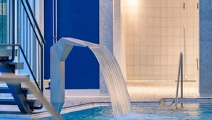 En inomhuspool med en hoppställning och en vattenattraktion.