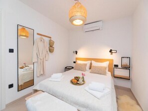 Ein Hotelzimmer mit einem Bett, einem Nachttisch, einem Spiegel und einer Hängelampe.